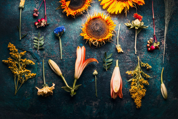 Autumn fall floral flat lay  made of flowers, sunflowers, leaves and canina berries on rustic vintage background , top view. Creative fall arrangement - Fotografie, Obrázek