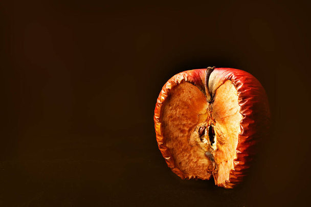 Shrivel red apple, close-up photo on black background. Copy space - Photo, Image