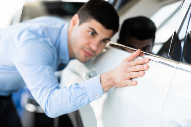 Guy Touching His New Auto In Dealership Showroom - Fotografie, Obrázek