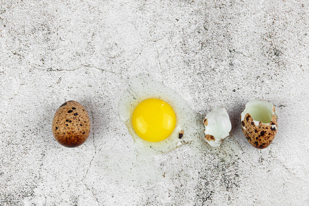 Fondo de Pascua o primavera con pequeños huevos frescos de codorniz. Ecoproducto. Huevos de codorniz sobre fondo gris concreto
. - Foto, imagen