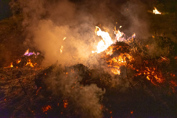 Grande pilha de cinzas queimando durante a noite
. - Foto, Imagem