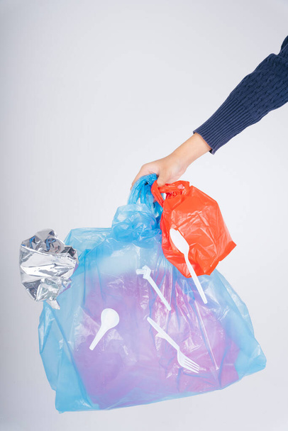 Nő keze újrahasznosítás műanyag zsák hulladék izolátum felett fehér háttér. - Fotó, kép