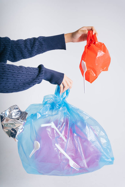 Mão de mulher reciclagem saco plástico resíduos isolar sobre fundo branco. - Foto, Imagem