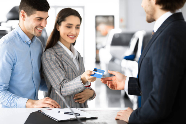 Pár Nákup nebo pronájem auta Dávání kreditní karty Prodávajícímu - Fotografie, Obrázek