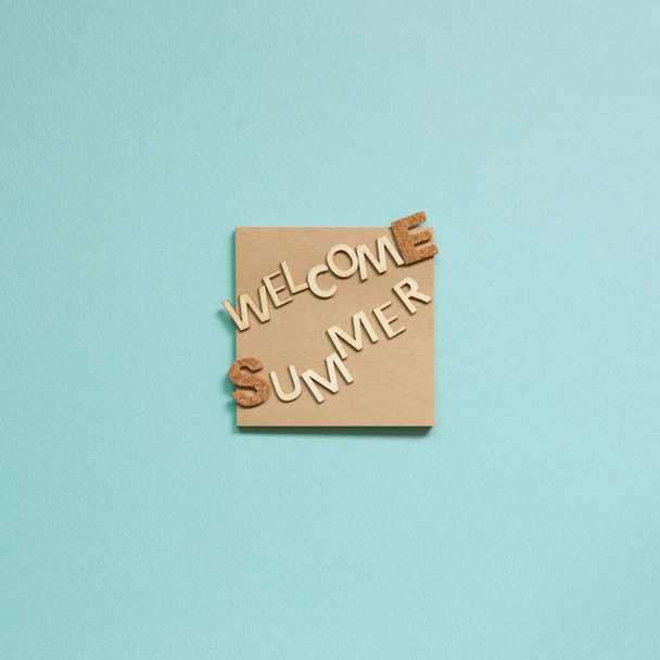 Palabra 'Bienvenido verano' en bloc de notas sobre fondo azul. Concepto vacaciones de verano. vista superior
 - Foto, imagen