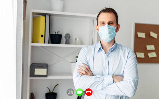Video call with young man in medical mask - Foto, Imagen