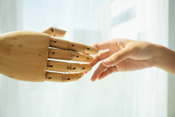 Mão de robô ciborgue de madeira e mão humana tremendo. - Foto, Imagem