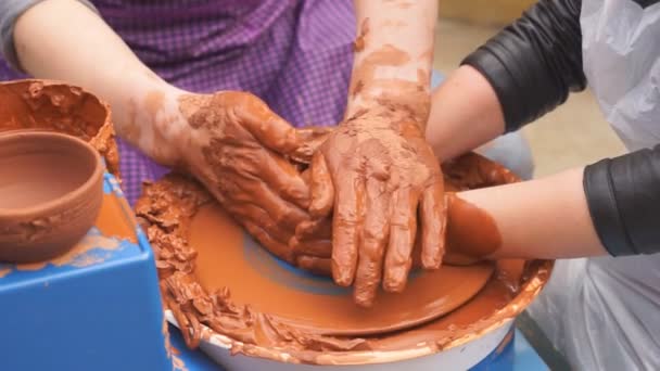Hands of potter teaches the child how to make pots. Concept - transfer of experience, - Footage, Video