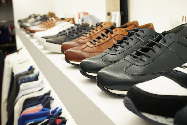 Sports shoes on a white shelf in a boutique - Foto, Imagem