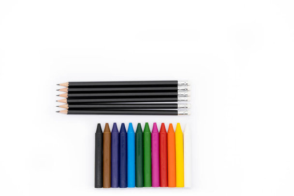 12 lápices de colores en la parte inferior de la imagen y 6 lápices negros en la parte superior de la imagen y todos los fondos blancos
 - Foto, imagen