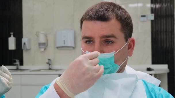 The patient puts on a protective mask after medical dental procedures - Materiał filmowy, wideo