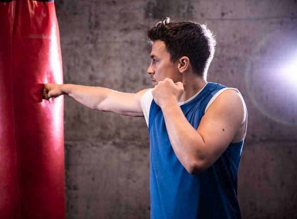 ボクシングの練習中に赤い袋をパンチ男性ボクサー - 写真・画像