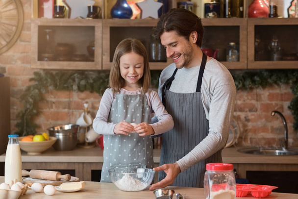 Ψήσιμο με τον μπαμπά. Κορίτσι βοηθώντας τον πατέρα προετοιμασία ζύμη για τα μπισκότα στην κουζίνα - Φωτογραφία, εικόνα