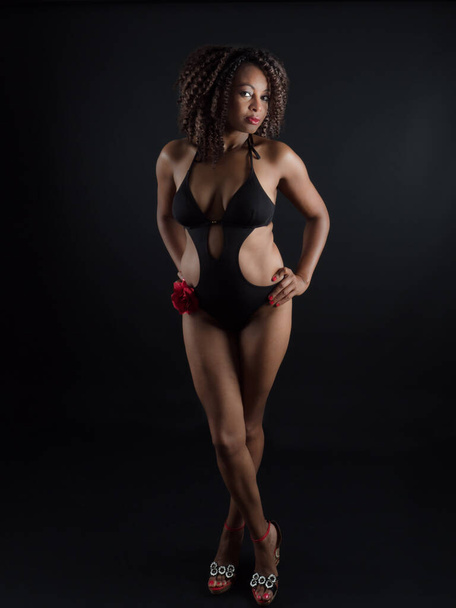 Vertical portrait of an attractive African American woman wearing a one piece swimsuit - 写真・画像
