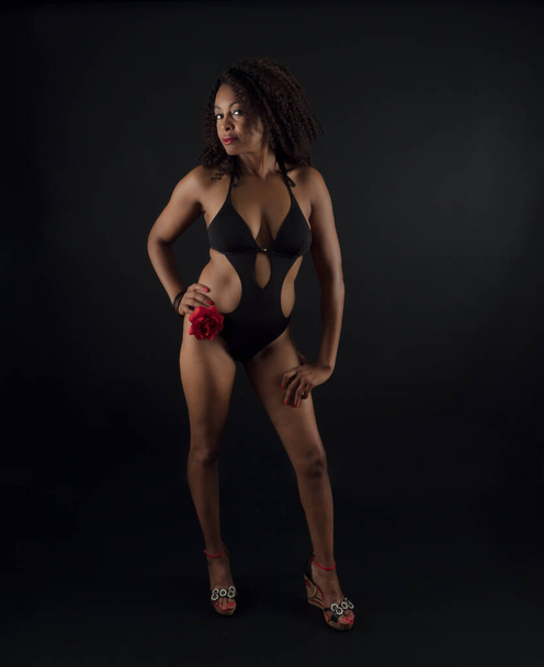 Vertical portrait of an attractive African American woman wearing a one piece swimsuit - Photo, image