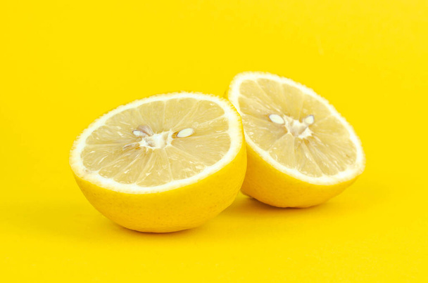 Twee halve citroen op gele achtergrond - Foto, afbeelding