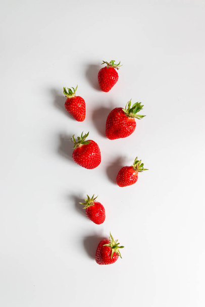 Organic delicious strawberry berries seamless pattern on grey background, top view, flat lay. Summer composition, minimal style - 写真・画像
