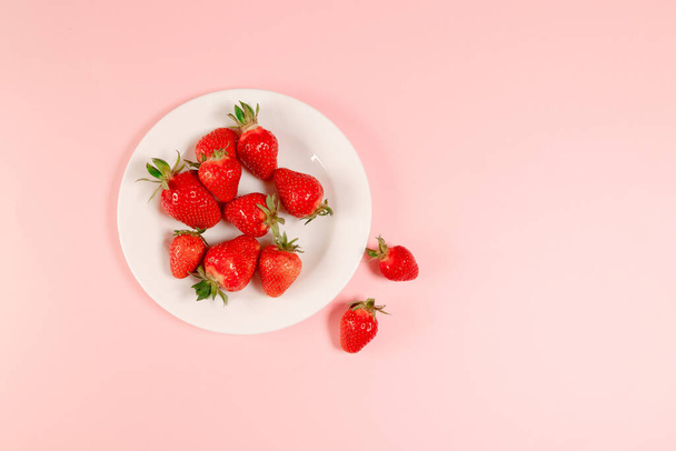 Top view strawberry in white plate on pink background, horizontal space for text - Foto, Bild