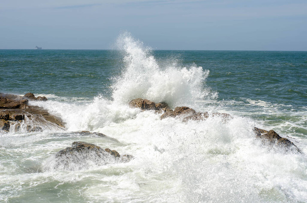 Wave with foam breaking of rock in ocean or sea - Fotó, kép