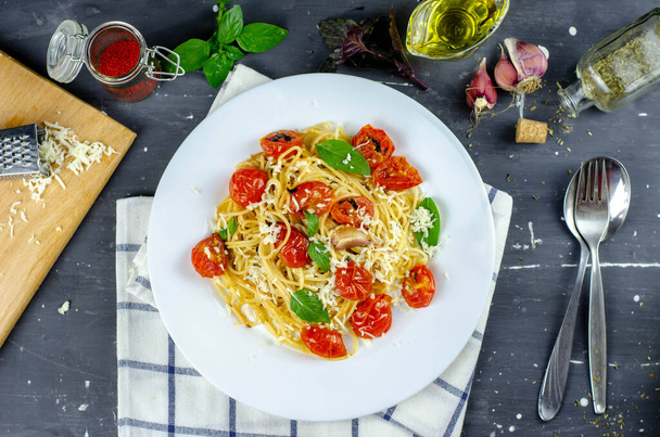 ガーリックチェリートマトとバジルの新鮮なパスタ.おいしいパスタプレート。スパゲティ。イタリア料理。イタリアだ。ローマだ。いい食事だ。健康食品。ベジタリアン。健康食品 - 写真・画像