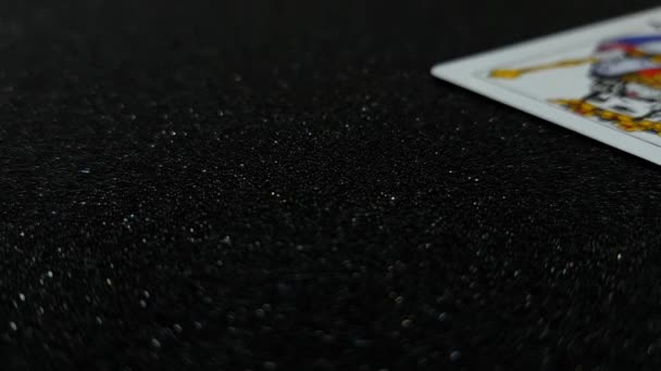 Macro vista di carte re che cadono su un tavolo nero lucido uno alla volta - Filmati, video