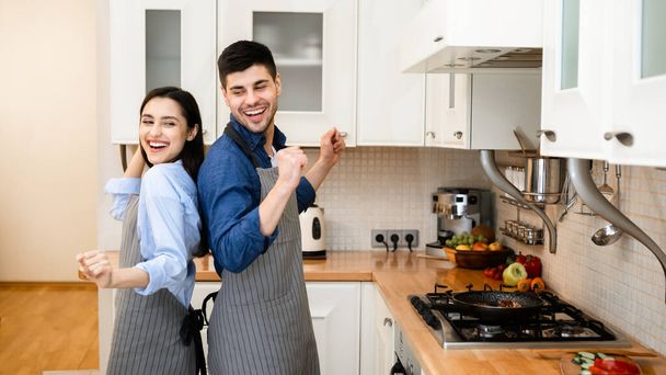 Nuori pari valmistaa illallista yhdessä kotona, tanssia - Valokuva, kuva