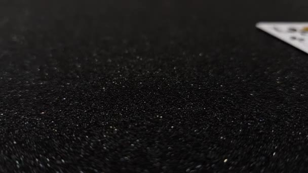 Μακροσκοπική άποψη των καρτών ρηγάδες που πέφτουν σε ένα μαύρο γυαλιστερό τραπέζι - Πλάνα, βίντεο