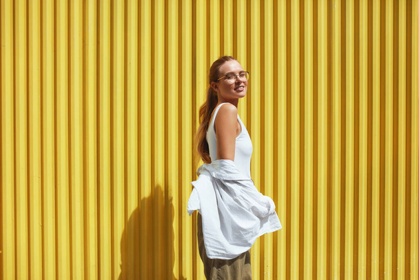 Woman. Portrait Of Sexy Model. Fashion Girl In Casual Clothes Standing Against Yellow Metal Fence. Female In White Shirt And Top Tank Looking At Camera. - Foto, Imagem