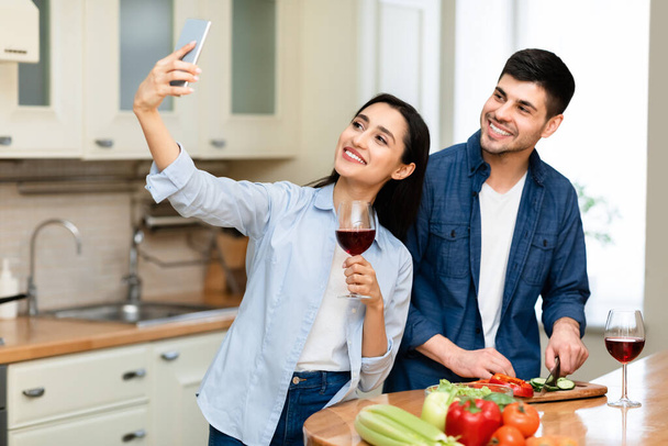 夫婦は自宅でキッチンで一緒にワインを飲む - 写真・画像