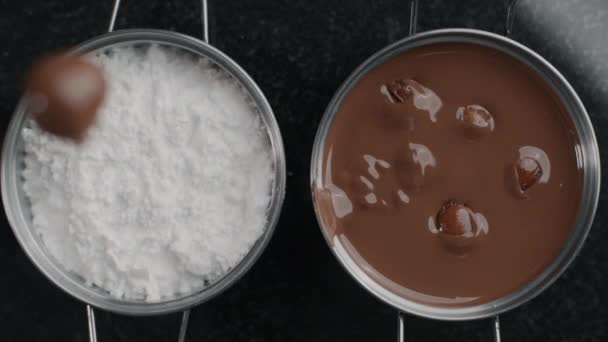 Tabletop shot: chef chocolatier gooit truffels in slow motion op het suikerpoeder, banketbakker maakt chocolade snoepjes en snoepjes, maakt desserts met suiker en chocolade, 1080p 240fps Prores HQ - Video