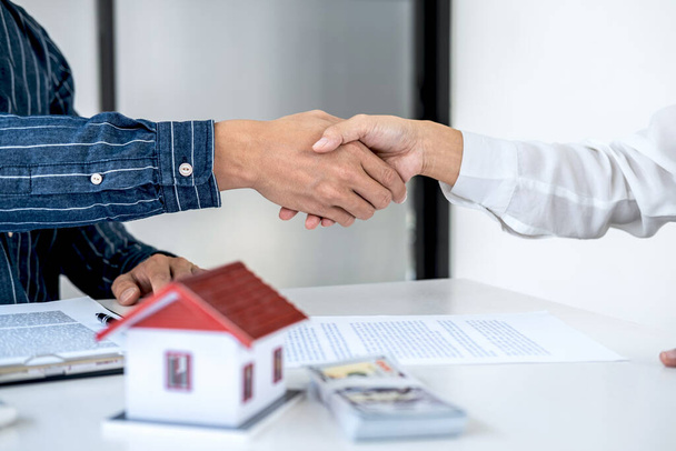 Real estate agent and customers shaking hands together celebrating finished contract after signing about home insurance and investment loan, handshake and successful deal. - Foto, afbeelding