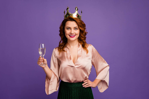 Photo of charming confident pretty chic lady hold sparkling wine glass tell toast birthday girl wear golden crown beige shirt blouse green skirt isolated purple color background - Foto, Bild