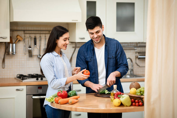 Happy couple preparing salad together at home - 写真・画像