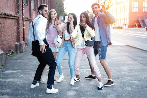 Happy friends having fun walking on city street center outdoor - Young millennials people dancing together - Foto, Imagen