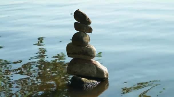 Pirámide de piedras junto al agua. simbolizando zen, armonía, equilibrio. Energía positiva
.  - Imágenes, Vídeo