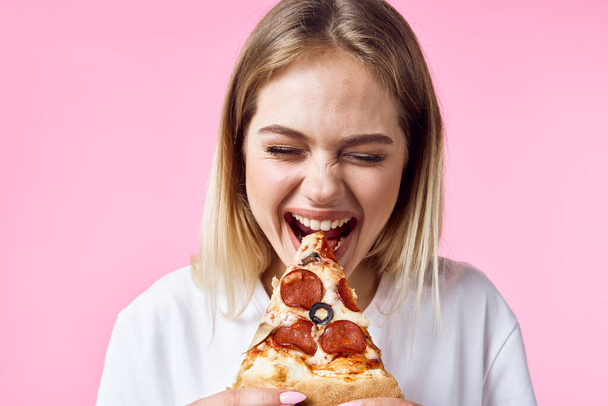 Женщина ест нездоровую пищу на цветном фоне модели
 - Фото, изображение