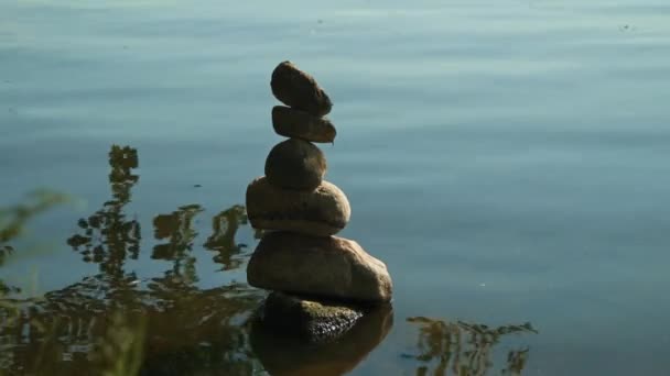 Pyramid of stones by the water. symbolizing zen, harmony, balance. Positive energy.  - Footage, Video