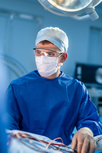 Surgery. Surgeon is operating with special equipment. Doctor s portrait. Modern medical background - Фото, зображення