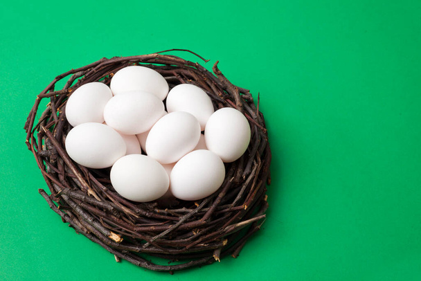 Bird nest with eggs isolated on green box background, top view, for copy space and product placement. - Valokuva, kuva