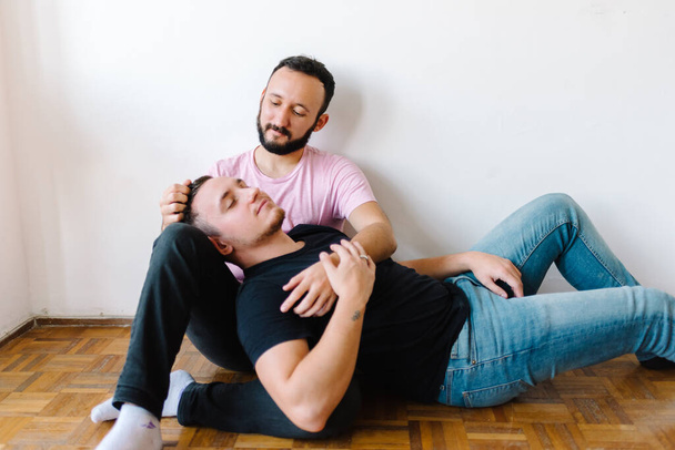 Stock photo of two caucasian homosexual men. One of them is sitting down and the other is lying in his lap. - Fotoğraf, Görsel