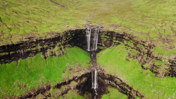 Aerial view of stunning waterfall in Faroe Islands. Aerial view of Fossa waterfall. Cloudy weather,establishing shot, no people. Majestic waterfall in wild rocky hillside. High quality footage. - 映像、動画