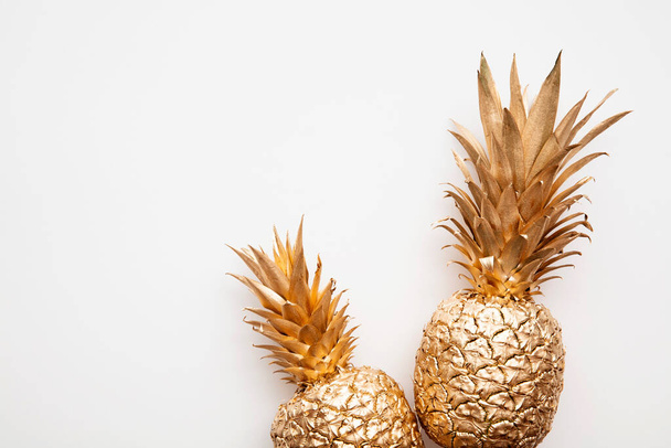 trendy tropical gold pineapple on a plain white background top view - Fotó, kép