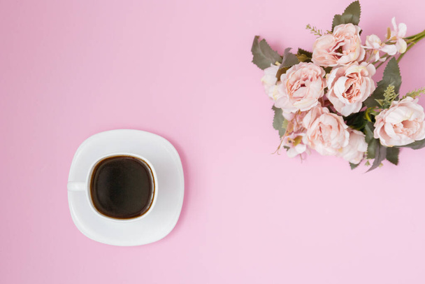 The concept of a morning coffee cup. Pink bouquet on a pink background. flat lay, copy space - Photo, image