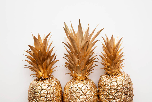 trendy tropical gold pineapple on a plain white background top view - Foto, Bild
