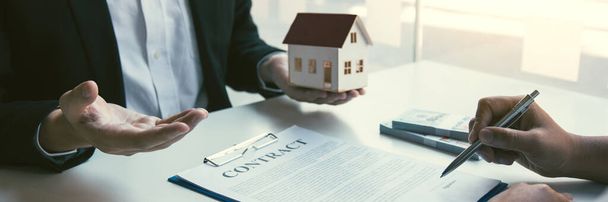Брокеры по продаже жилья и инвесторы в недвижимость обмениваются с инвесторами, которые подают наличные от руки агента. - Фото, изображение