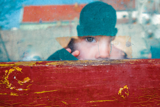 Kind blickt ängstlich durch Fenster - Foto, Bild