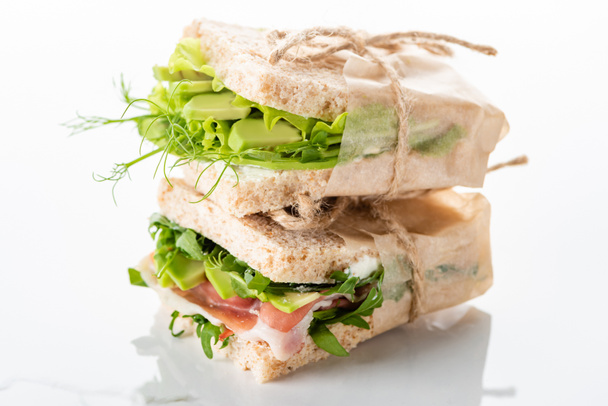 friss zöld szendvicsek avokádóval és jamon márványfehér felületen - Fotó, kép
