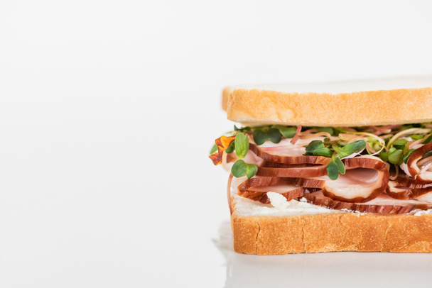 friss ízletes szendvics hússal és csírával fehér felületen - Fotó, kép