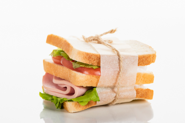 fresh delicious sandwich with sliced sausage and lettuce on white surface - 写真・画像