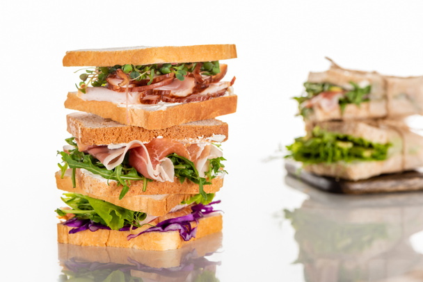 selective focus of fresh sandwiches with arugula and meat on white surface  - Fotó, kép